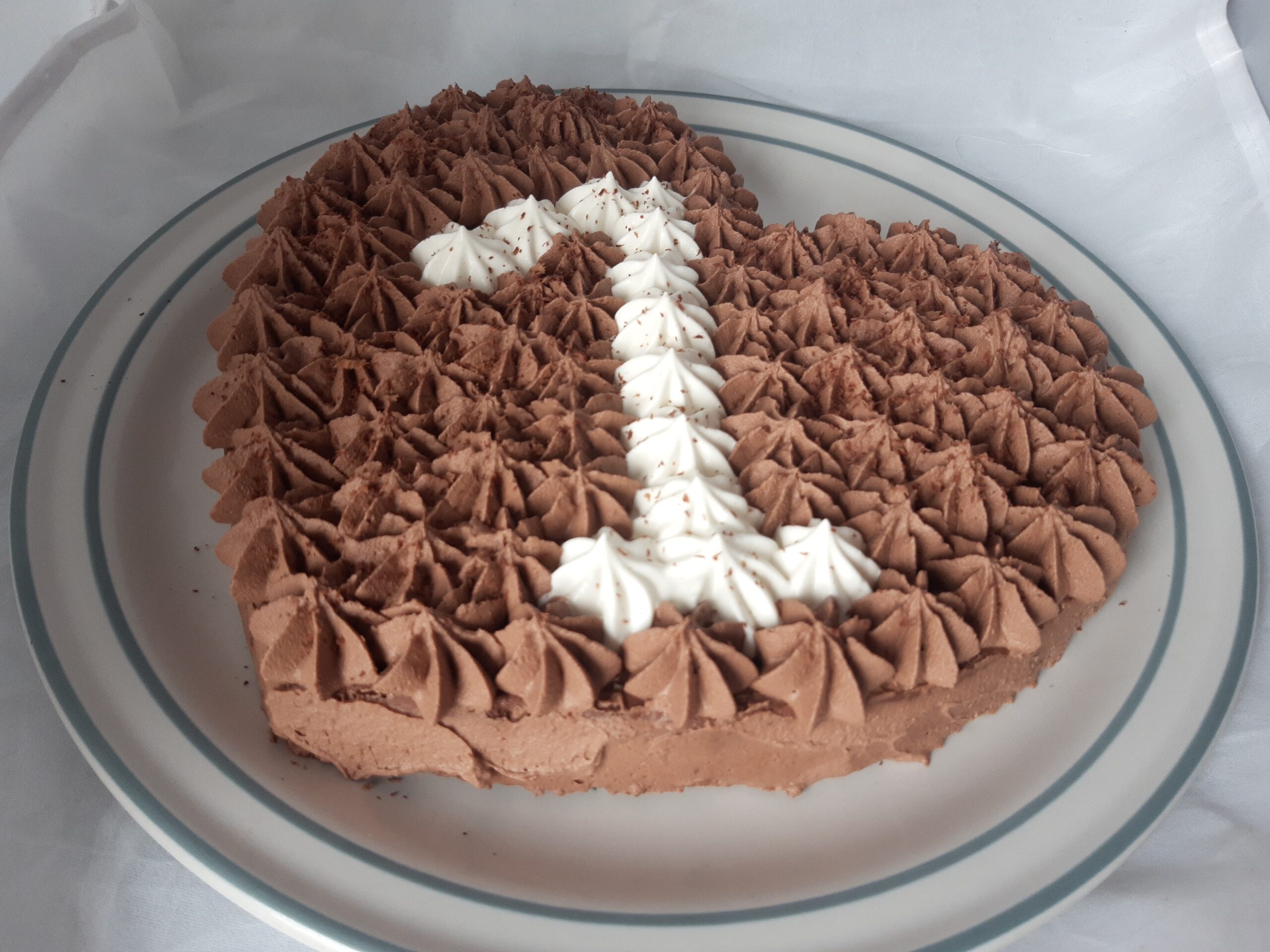Gâteau en forme de coeur au chocolat, avec le chiffre 1 poché dessus