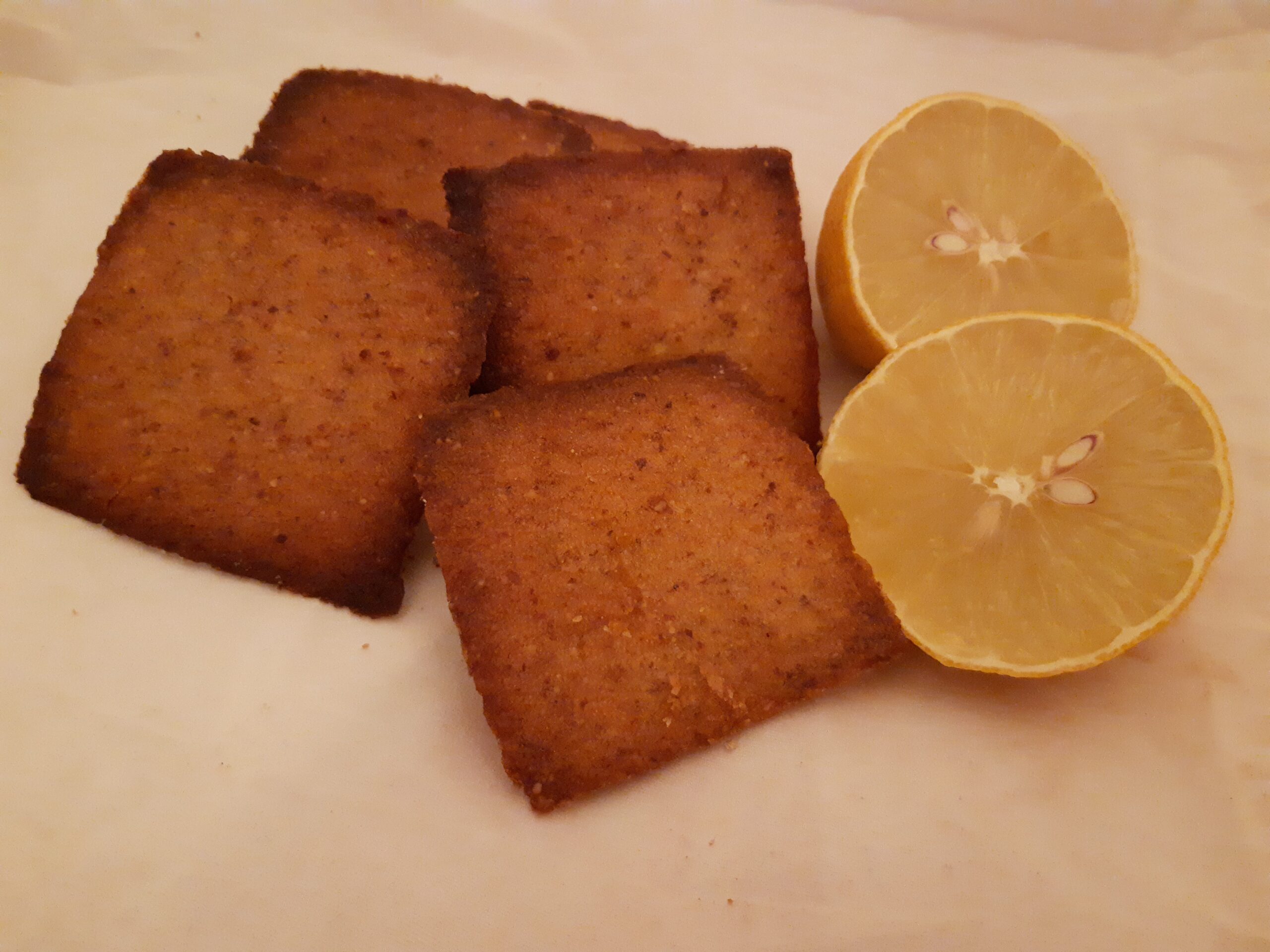 Quatre financiers au citron, avec un citron coupé à côté