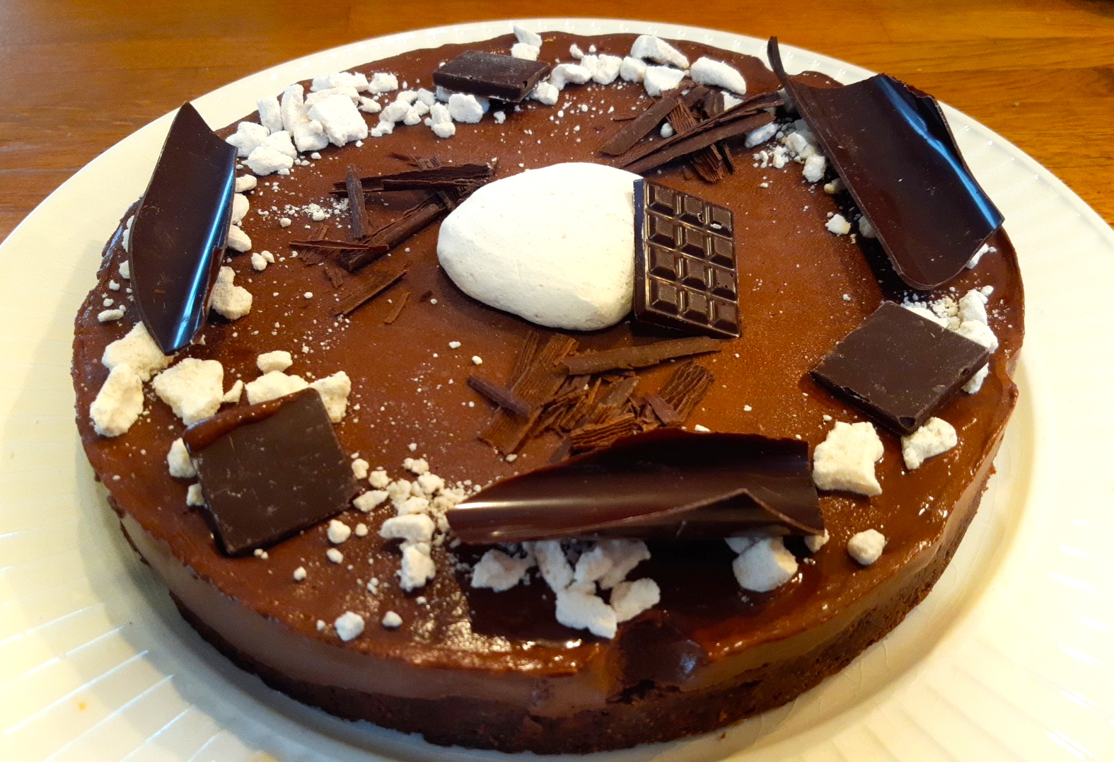 Gâteau Fraîcheur chocolat, avec beaucoup de décorations comestibles, sur une assiette blanche